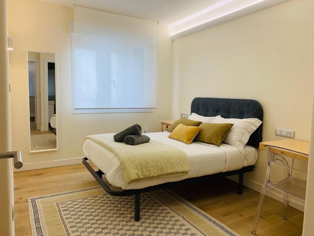 sypialnia z łóżkiem z żółtymi poduszkami i lustrem w obiekcie Alameda Lofts Pontevedra w mieście Pontevedra