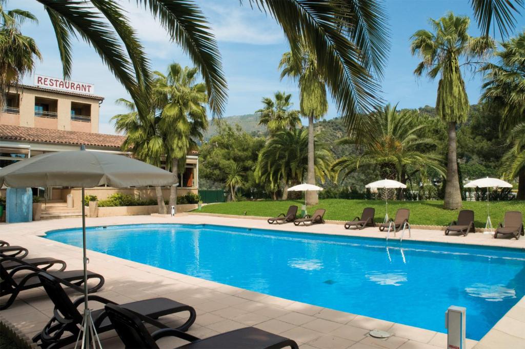 - une piscine avec des chaises et des parasols dans l'établissement Promotel, à Carros