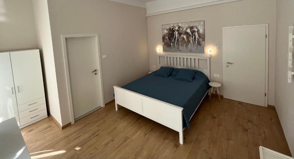 sypialnia z łóżkiem z niebieską pościelą i lustrem w obiekcie Apartment Check in w Puli