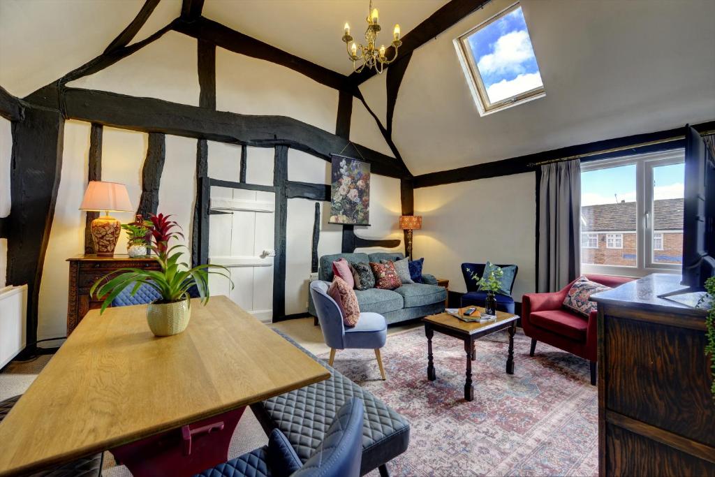 亞芬河畔史特拉福的住宿－Loft Cottage by Spa Town Property - 2 Bed Tudor Retreat Near to Stratford-upon-Avon, Warwick & Solihull，客厅配有沙发和桌子