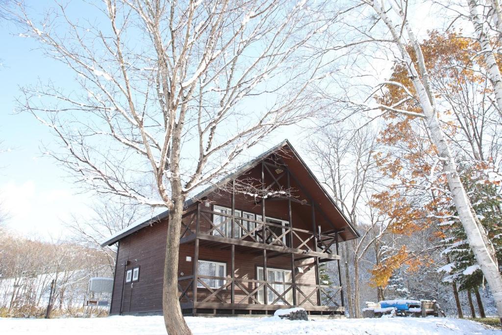 a log cabin in the snow with a tree at Esashi-gun - Cottage - Vacation STAY 38366v in Pinneshiri