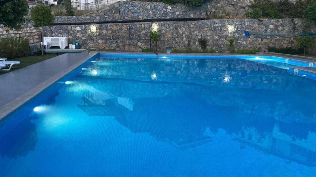 a large blue swimming pool with lights on it at Semiramis Garden in Milas