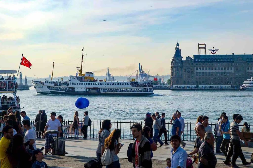 a group of people walking on a pier near the water with a boat at İstanbul Kadiköy Harbour-, Cozy place, Feel@Home in Istanbul