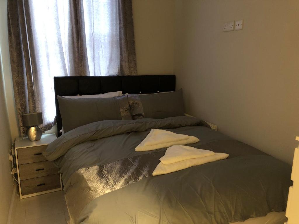 ein Bett mit zwei Kissen darauf in einem Schlafzimmer in der Unterkunft THE CRESCENT in Rhyl