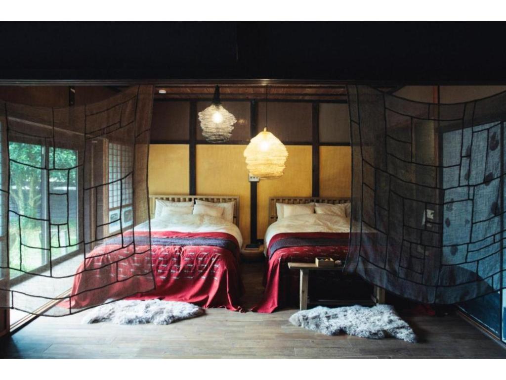 a bedroom with two beds in a room with windows at Hyogo private house yogoto - Vacation STAY 00235v in Kamikawa