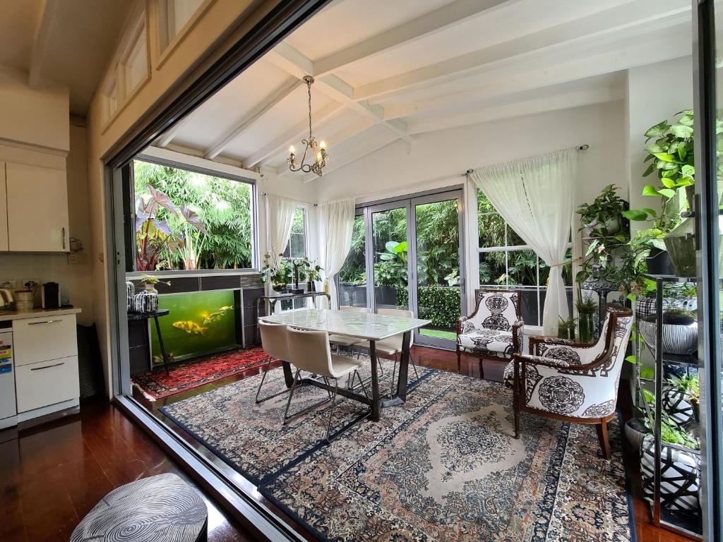 a dining room with a table and chairs and a tv at Bamboo House, Close to the City & Airport & Train station and Brighton Le Sands Beach in Sydney