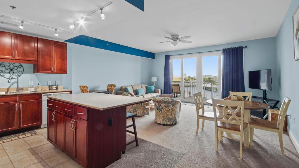 a kitchen and living room with a table and chairs at Laketown Wharf #113 by Nautical Properties in Panama City Beach