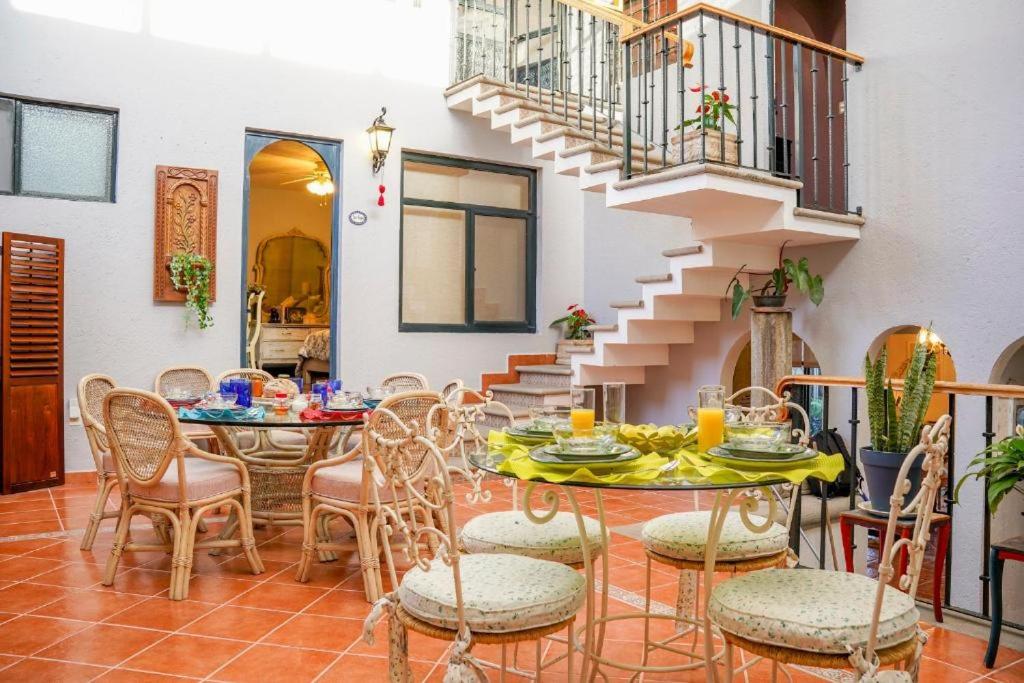 ein Esszimmer mit einem Tisch, Stühlen und einer Treppe in der Unterkunft Villa Orbayu B&B Boutique in Cuernavaca