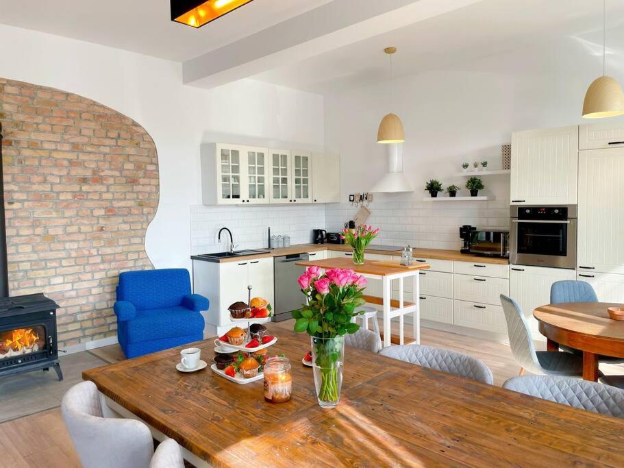 eine Küche und ein Esszimmer mit einem Tisch und einem Kamin in der Unterkunft Landhof in Ganschendorf, Landhaus Seenah in Sarow