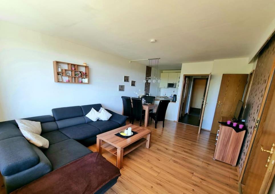 ein Wohnzimmer mit einem blauen Sofa und einem Tisch in der Unterkunft Harz-Idylle mit Sauna & Pool: Entspannung pur. in Braunlage