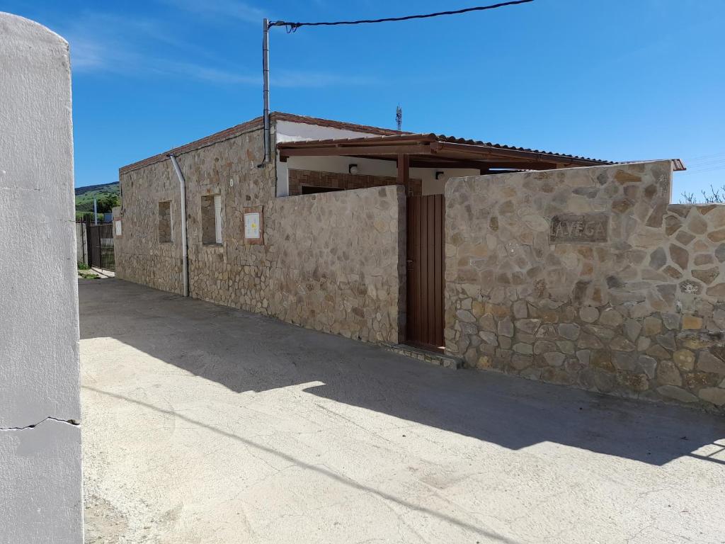 a building with a stone wall and a wooden door at La Vega in Tarifa