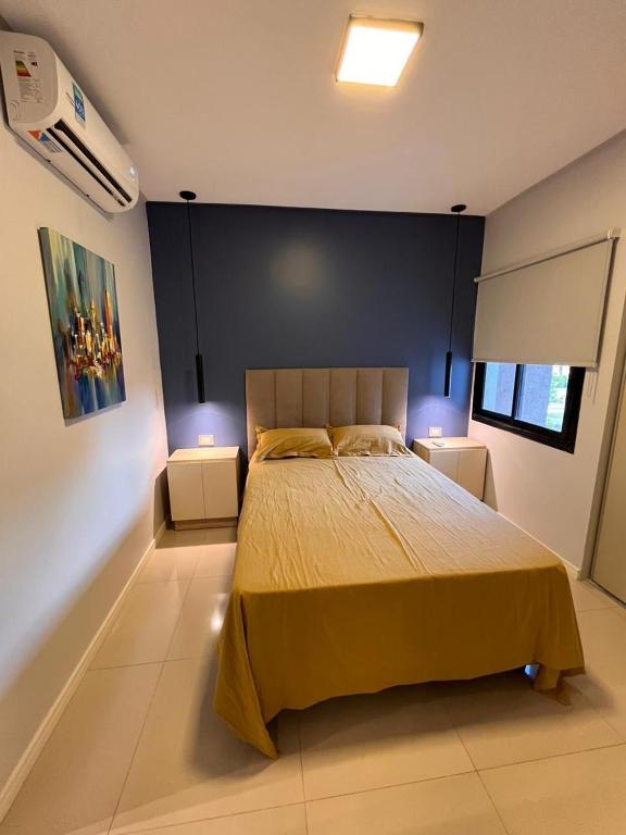 1 dormitorio con 1 cama grande y 2 mesitas de noche en Hermoso Departamento 2 ambientes/1 dormitorio. Descubrí el Malecón del Buena Vista - Yerba Buena/ Tucumán en Yerba Buena