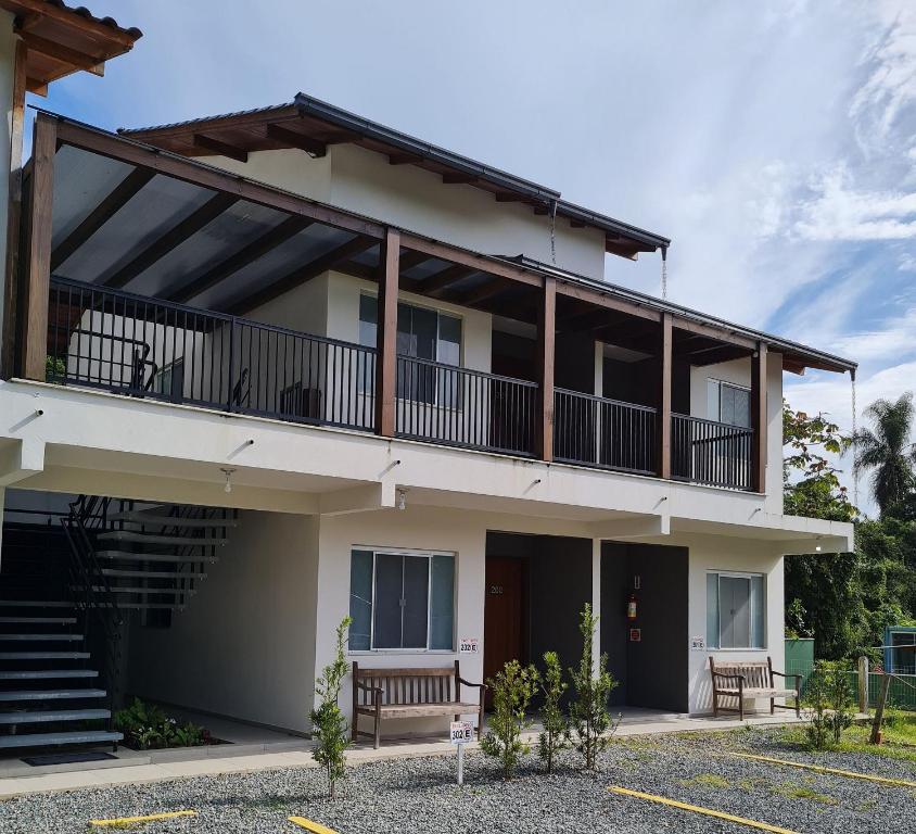 een appartementencomplex met een balkon en een trap bij Ipê Eco Village in Penha
