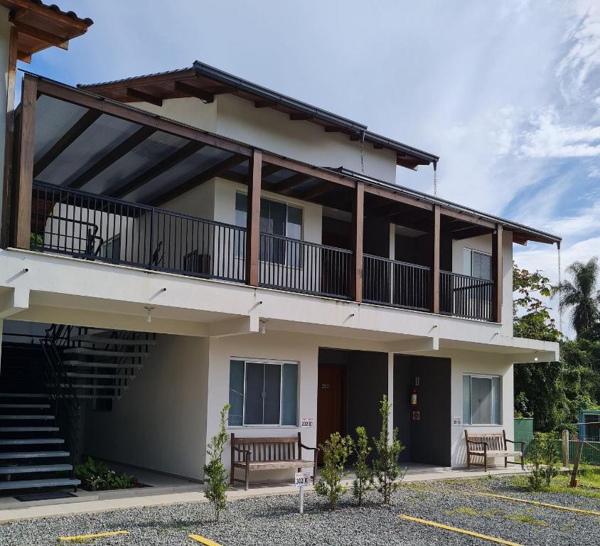 un edificio de apartamentos con balcón y escaleras en Ipê Eco Village, en Penha