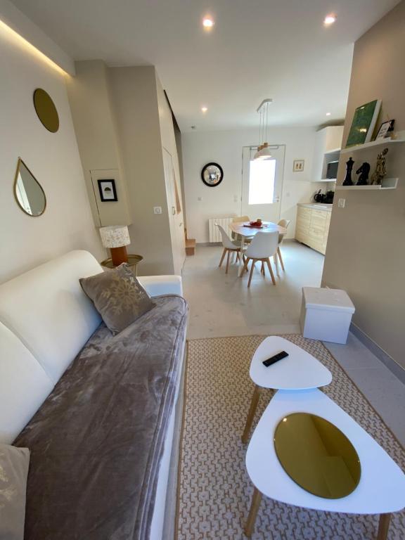 a living room with a couch and a table at Appartement standing 2 pièces tout équipé avec jardin et parking privé 