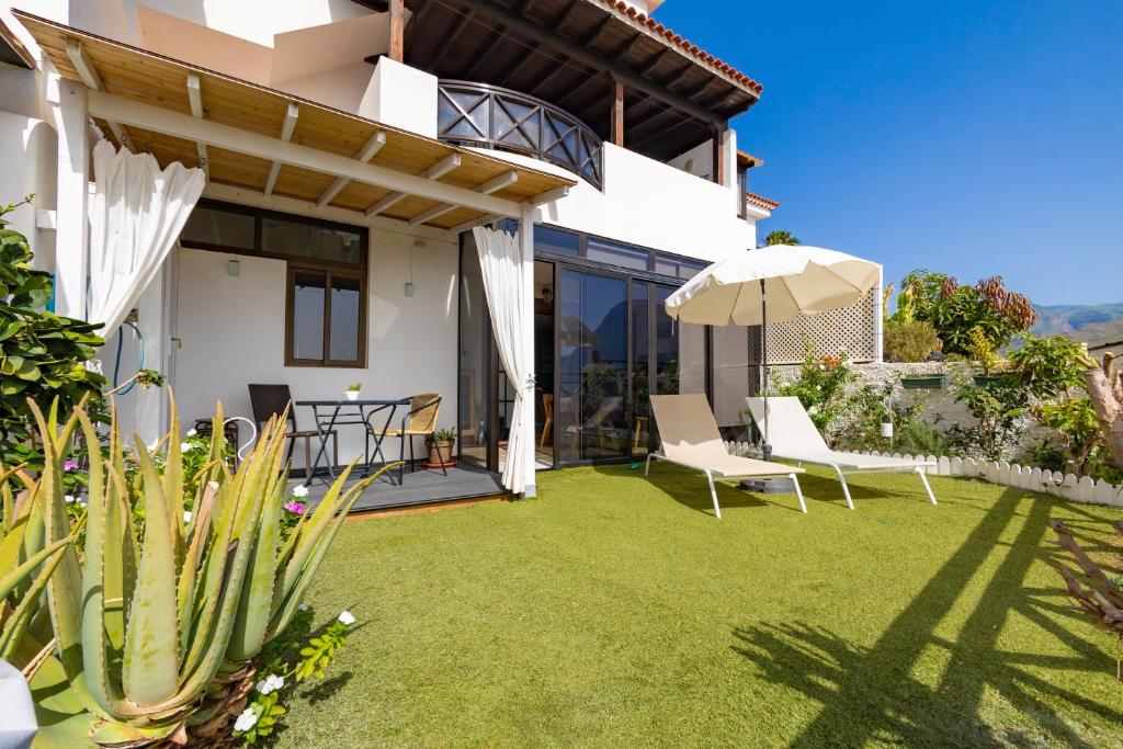 - une terrasse avec 2 chaises et un parasol dans l'établissement Casa Zora, à Agaete