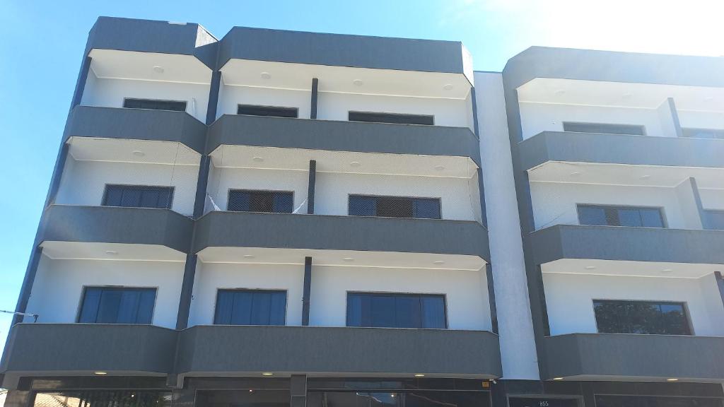 um edifício branco alto com muitas janelas em Apartamento charmoso em Saquarema