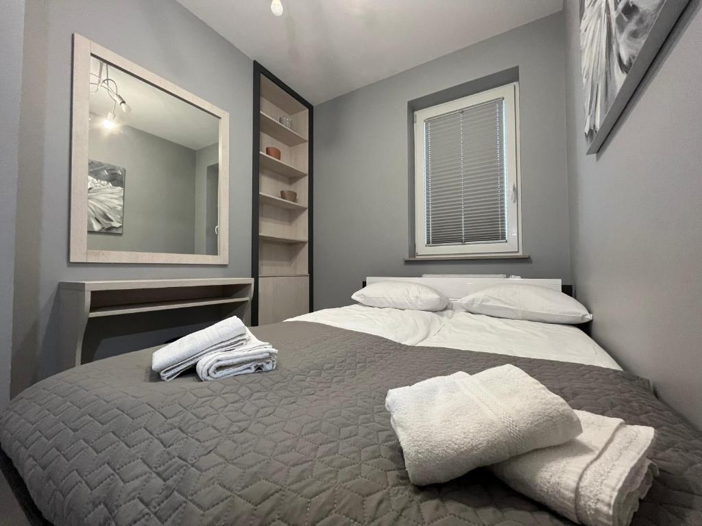 um quarto com 2 camas e toalhas em Apartamenty Planeta II - Koszalin centrum em Koszalin
