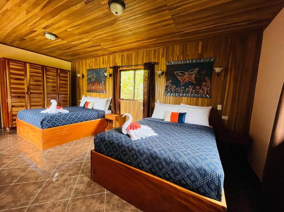 a bedroom with two beds with swans on them at TucanTico Lodge ~ Casa # 3 in Monteverde Costa Rica