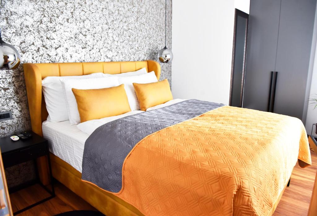 a bedroom with a bed with an orange and gray blanket at Apartman Renata in Zaprešić