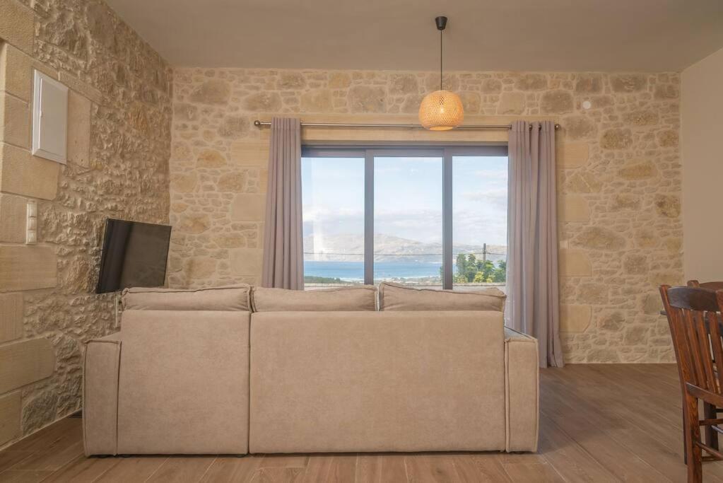 a living room with a couch and a large window at Fanouria's home in Kalleryianá