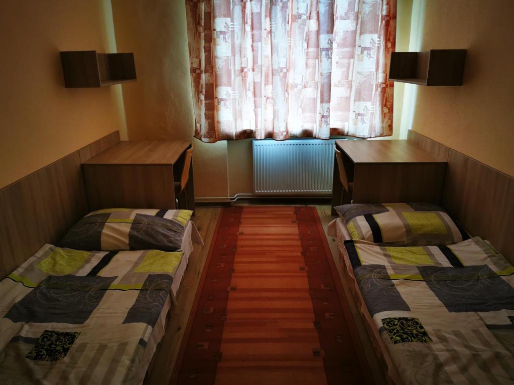 two beds in a small room with a window at Hostel SOS Moldava in Moldava nad Bodvou