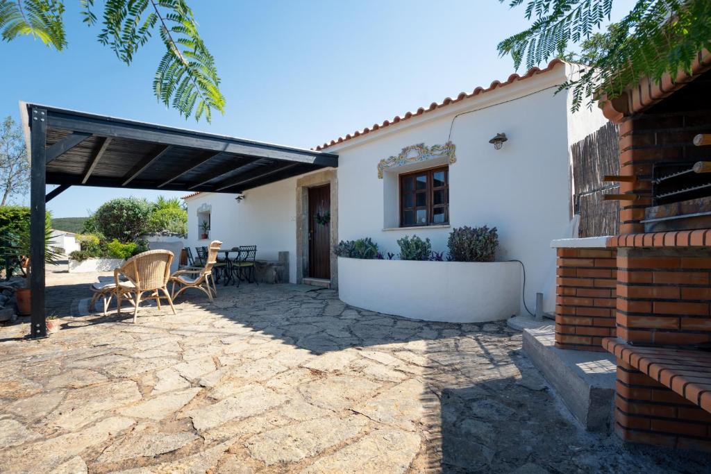 a patio with a table and chairs in front of a house at Cosy Farmhouse Quinta da Eira 140 years old in Loulé