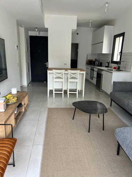 a living room with a table and a kitchen at Utopia apartment *top location* in Tel Aviv