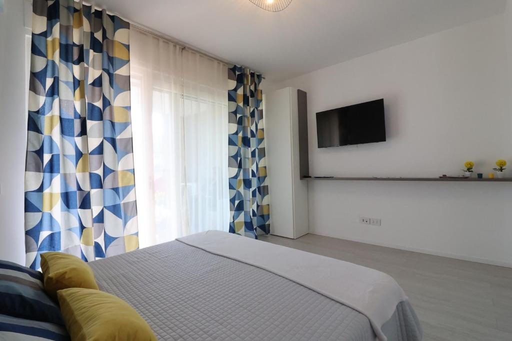 a bedroom with a bed and a tv and a window at Ad un passo dal mare in Bari