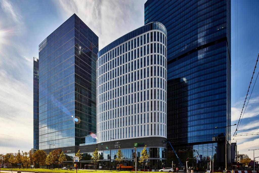 two tall glass buildings in a city at Holiday Inn Express - Warsaw - The HUB, an IHG Hotel in Warsaw