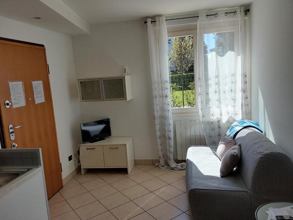 ein Wohnzimmer mit einem Sofa und einem Fenster in der Unterkunft La casa di Alyss in Bergamo
