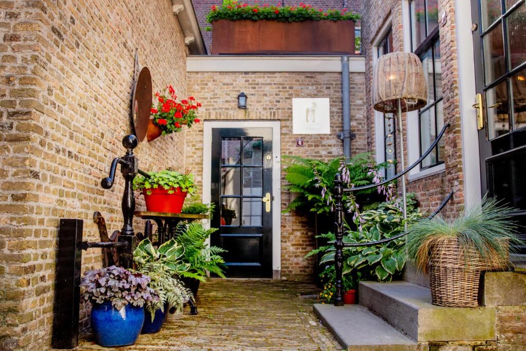 a brick building with a door with plants and flowers at Pension B&B Pluk in Zierikzee