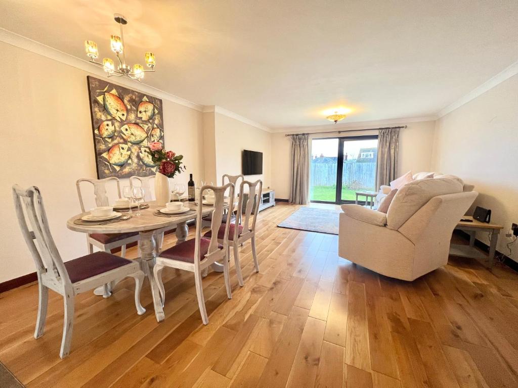 a living room with a dining room table and chairs at 3 Bedroom house - Sandown in Sandown