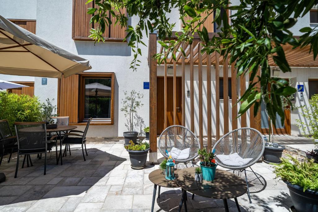 a patio with two chairs and tables with plants at Stay U-nique Studio apartment in Orašac in Orasac