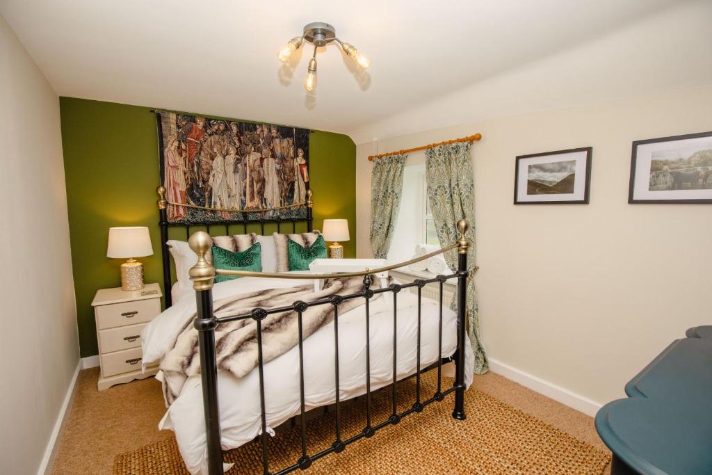 um quarto com uma cama e paredes verdes em Gardeners Cottage - Rudge Farm Cottages em Bridport