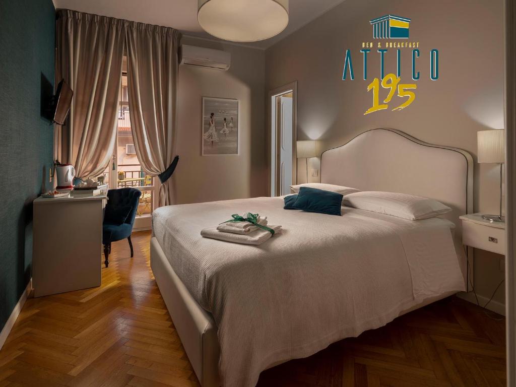 1 dormitorio con 1 cama blanca grande y escritorio en Attico 195, en Salerno