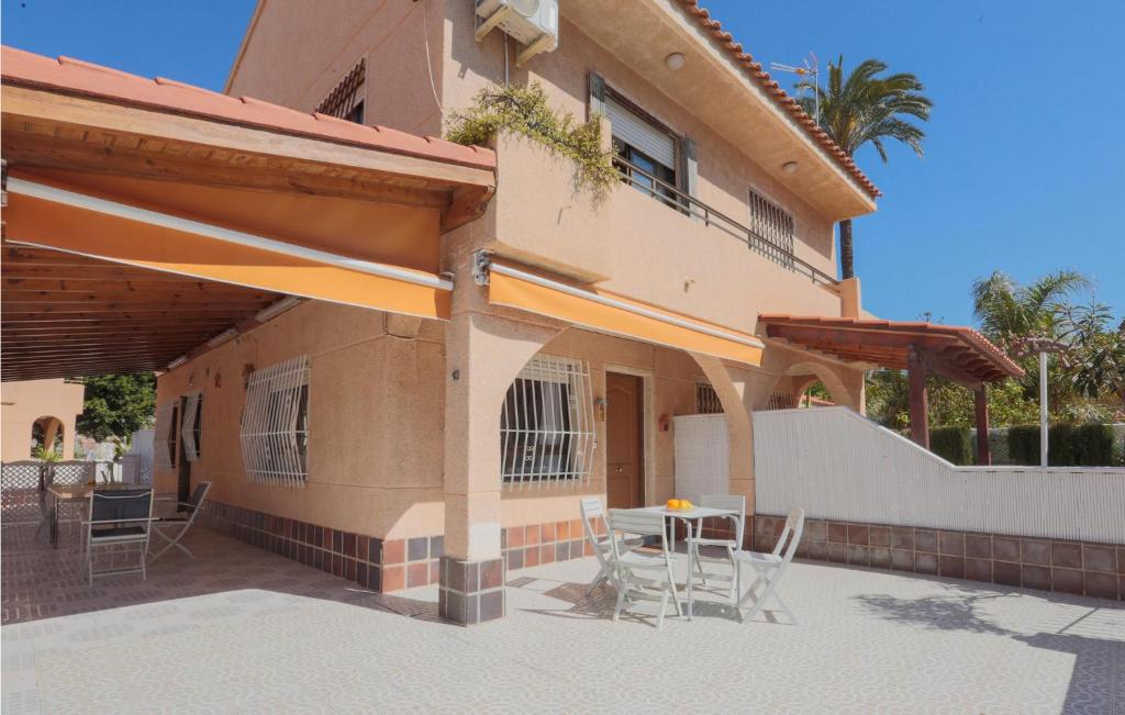 un edificio con tavolo e sedie di fronte di Cozy Home In Los Alczares With Kitchen a Los Narejos