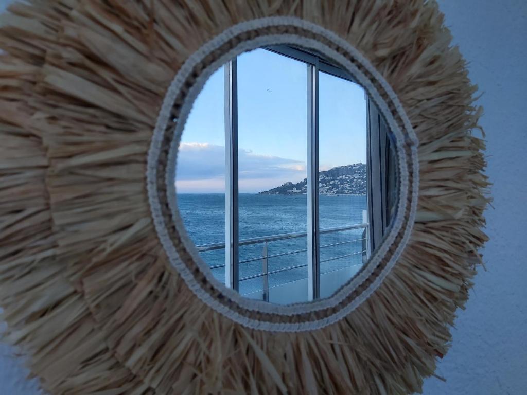 uno specchio a parete con vista sull'oceano di Appart Santa Margarida a Roses
