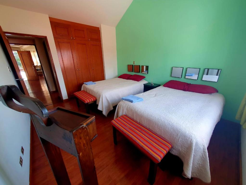 a bedroom with two beds and a table and a chair at Executive Airport Apartment Guatemala in Guatemala