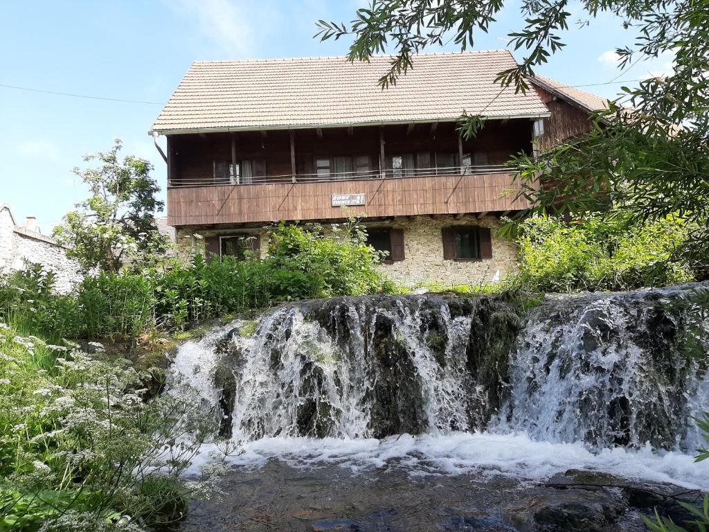 a house with a waterfall in front of a building at Sobe Ivan Rastoke 21 in Slunj