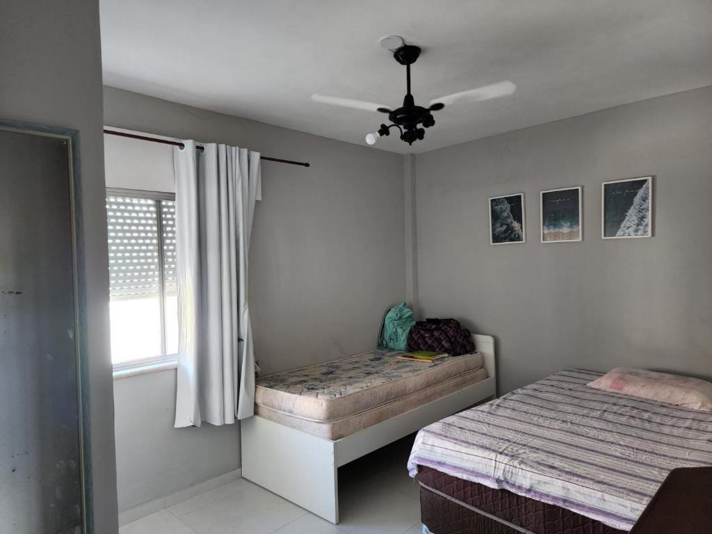 1 dormitorio con 2 camas y ventilador de techo en CABO FRIO Praia do Forte Fte Mar charmoso 2 qtos 7 pessoas, en Cabo Frío