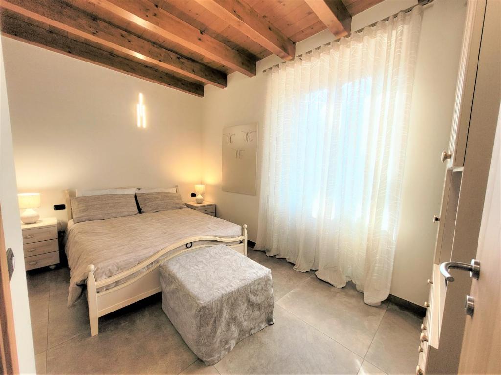 Eva Lake Endine Hospitality في إندين جياناو: غرفة نوم بها سرير ونافذة كبيرة