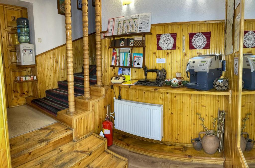 eine Küche mit Holzwänden, Holzböden und einer Treppe in der Unterkunft Guest rooms Colorit in Kopriwschtiza