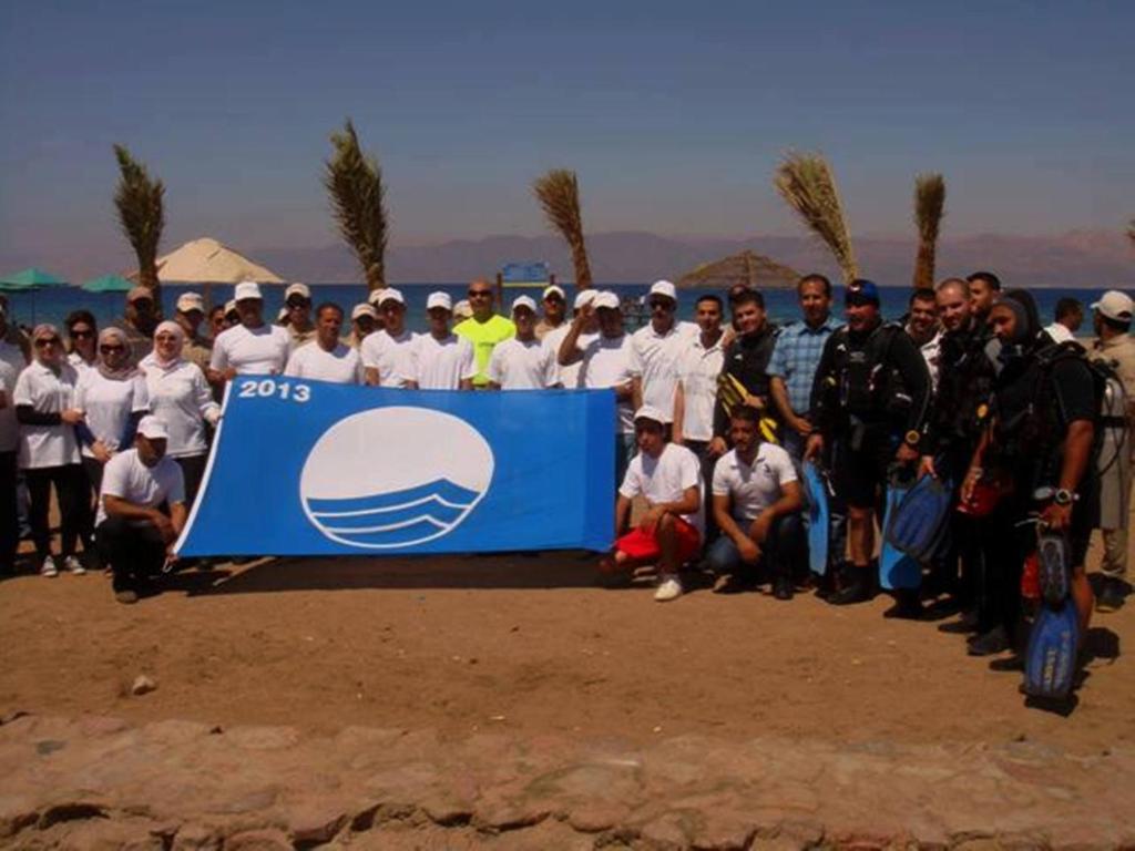 a group of people posing for a picture with a sign at Arab Divers Dive Center and Bed & Breakfast in Aqaba