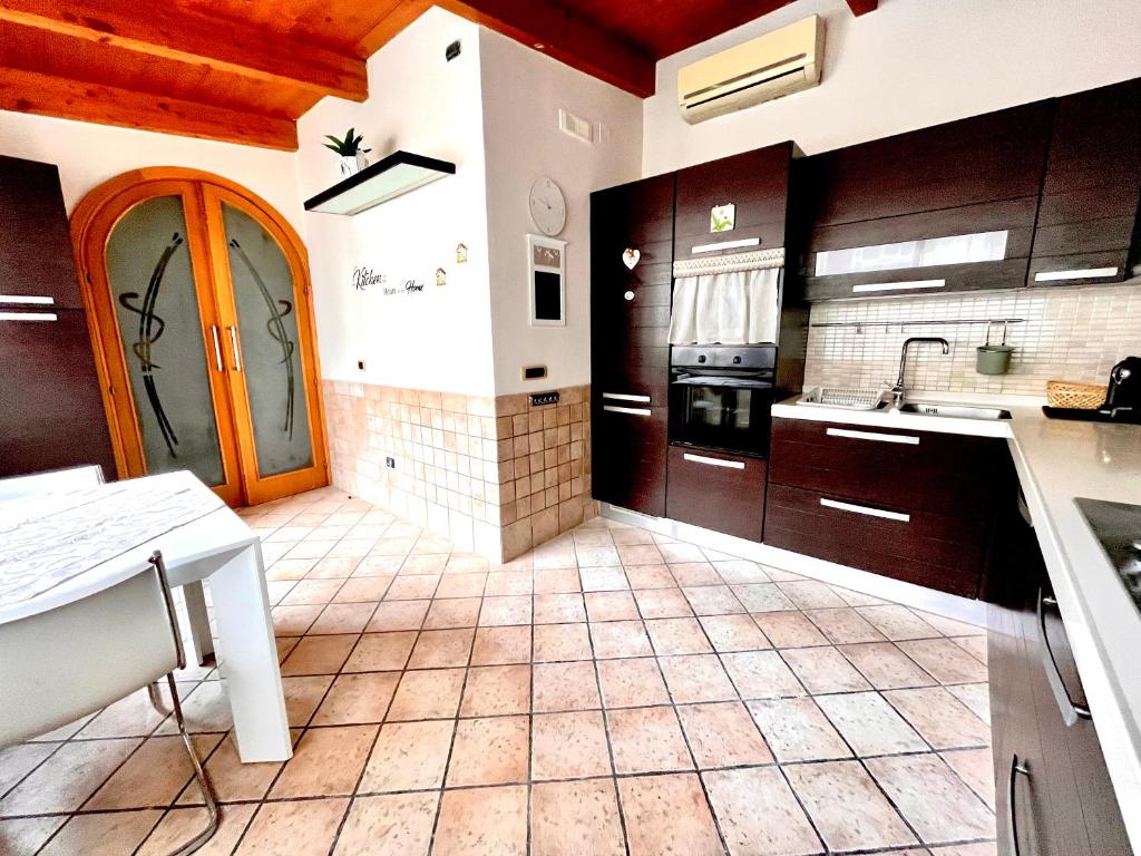 a kitchen with wooden cabinets and a tile floor at Sivy Home casa vacanze Napoli in Naples