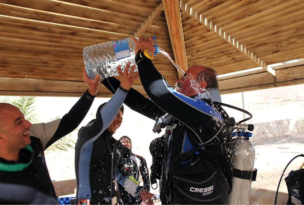 a group of people holding up a water bottle at Arab Divers Dive Center and Bed & Breakfast in Aqaba