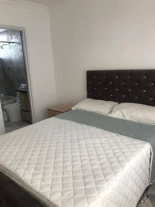 a bed in a bedroom with a white mattress at Apartamento en el centro de Pitalito in Pitalito