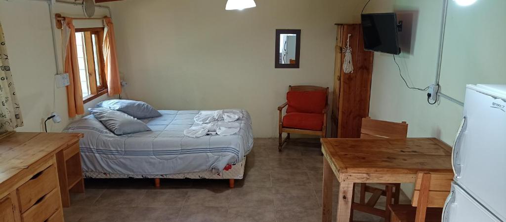 um pequeno quarto com uma cama e uma mesa em Choique em San Carlos de Bariloche