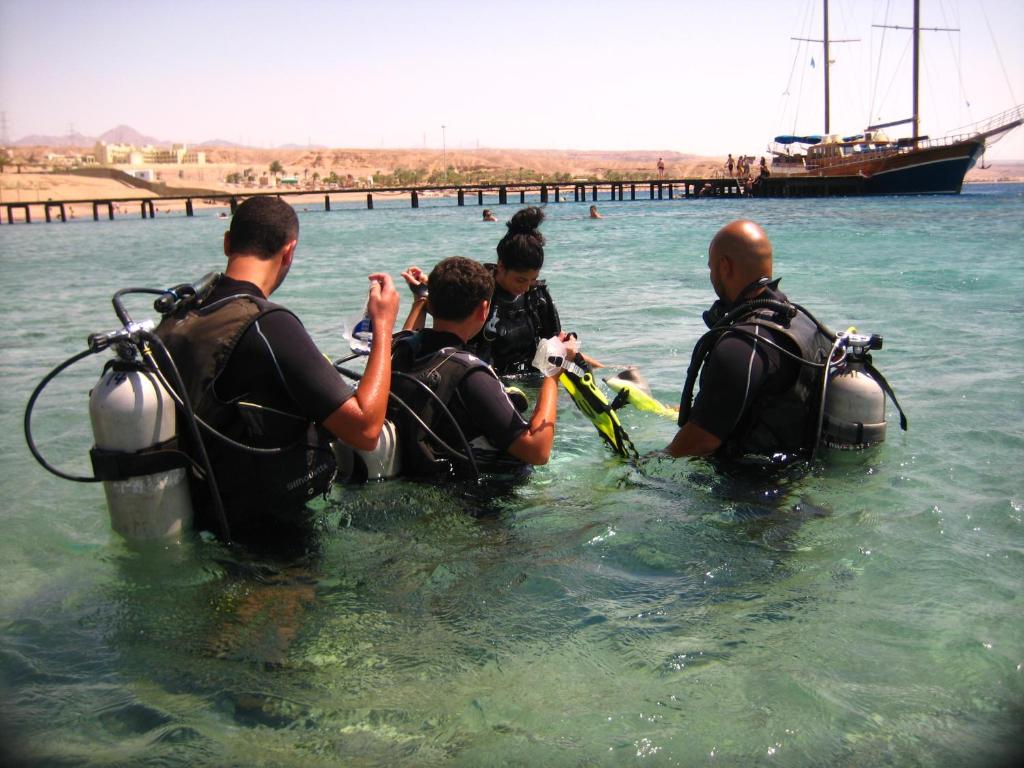 a group of people in the water with a boat at Arab Divers Dive Center and Bed & Breakfast in Aqaba