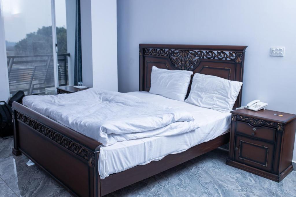 Un dormitorio con una cama y un teléfono en una mesita de noche en Regal Residency en Rawalpindi